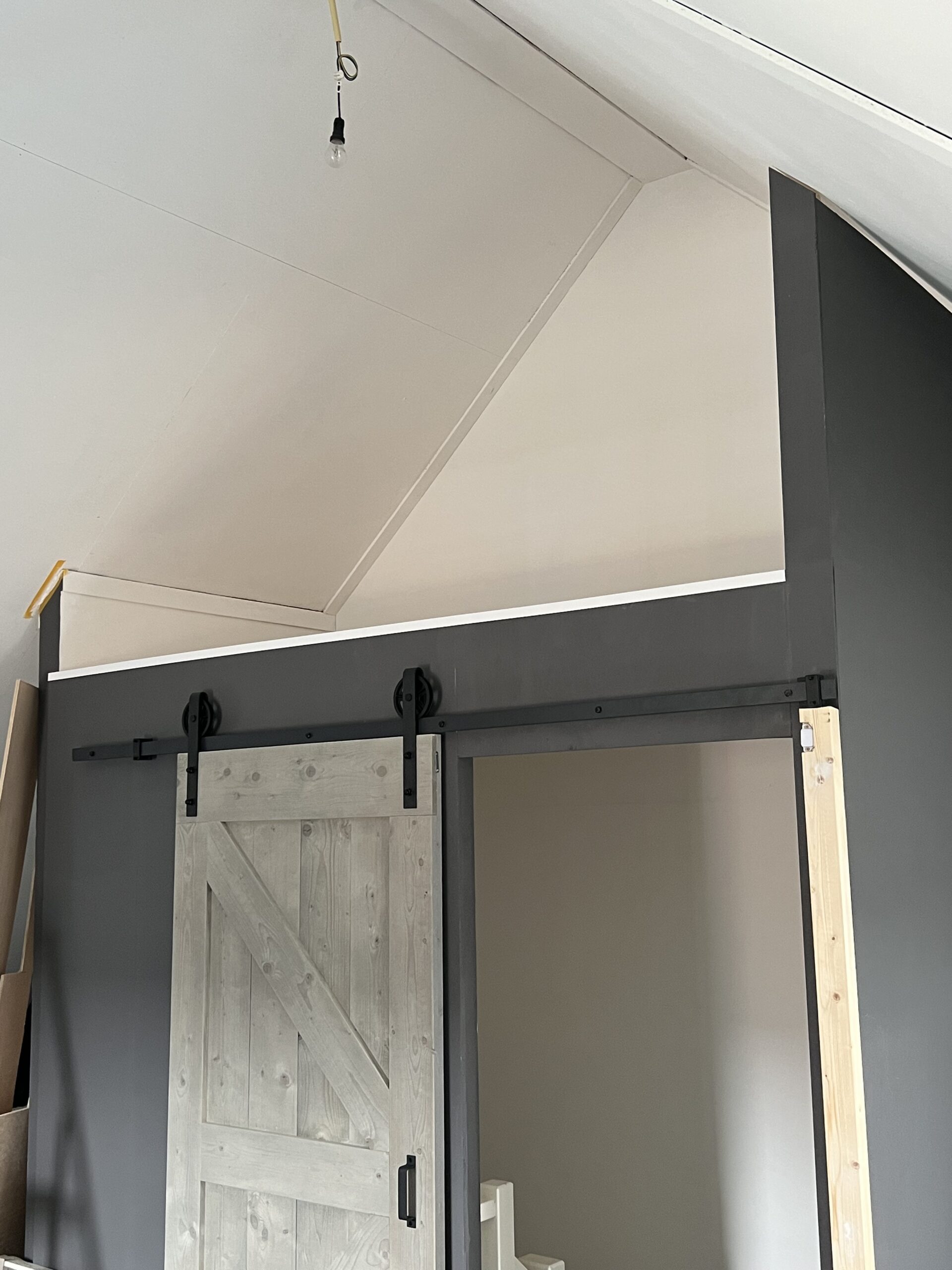 Grijze houten roldeur op de zolder, op maat gemaakt.